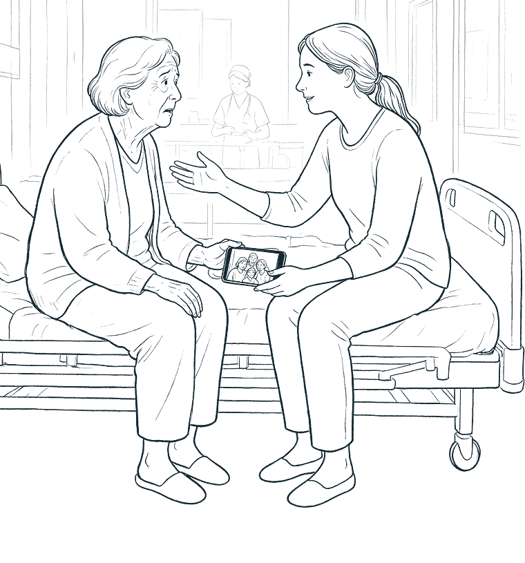 A relative sits beside an older woman on a hospital bed and shows her a family photo on a phone.